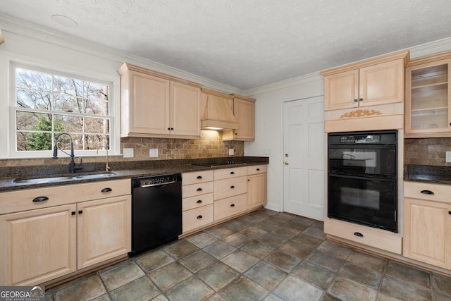 kitchen with tasteful backsplash, dark stone countertops, sink, and black appliances