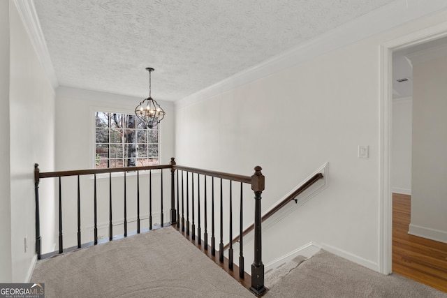 staircase featuring crown molding, a textured ceiling, and a notable chandelier