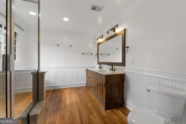 bathroom featuring crown molding, wood-type flooring, toilet, and vanity