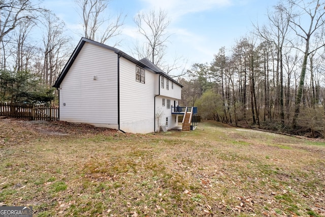 view of property exterior with a wooden deck and a lawn