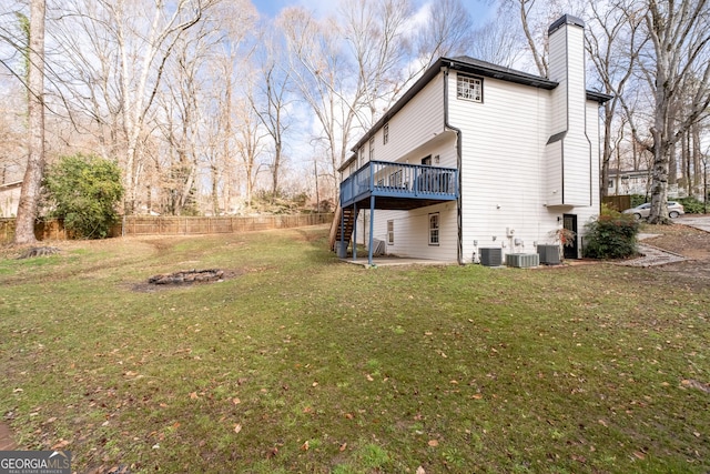 exterior space with cooling unit, a deck, and a lawn