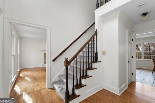 stairs featuring hardwood / wood-style flooring and crown molding