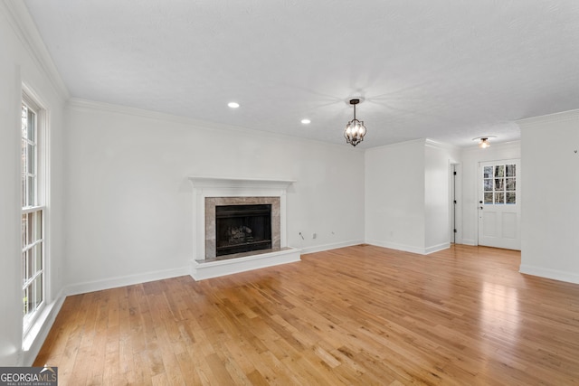 unfurnished living room with crown molding, a healthy amount of sunlight, and a fireplace