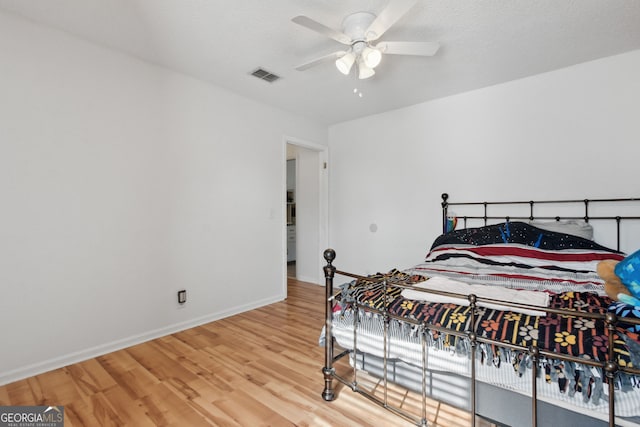 bedroom featuring a textured ceiling, wood-type flooring, and ceiling fan