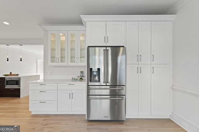 kitchen with white cabinetry, ornamental molding, and stainless steel appliances