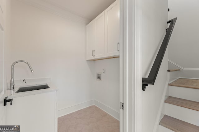 laundry room featuring cabinets, crown molding, hookup for a washing machine, and sink