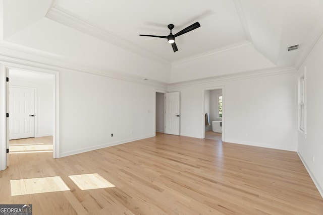 unfurnished room with a tray ceiling, light hardwood / wood-style flooring, ornamental molding, and ceiling fan