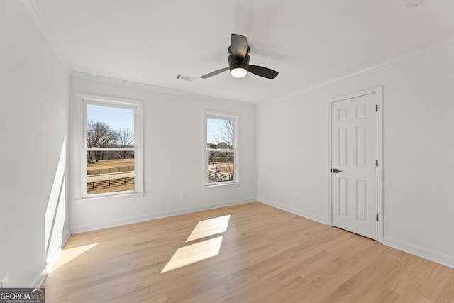 unfurnished room featuring ceiling fan, ornamental molding, light wood-type flooring, and a wealth of natural light