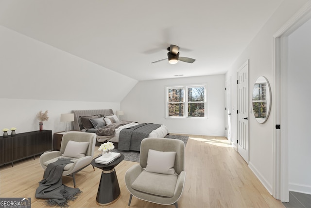 bedroom with vaulted ceiling, ceiling fan, and light wood-type flooring