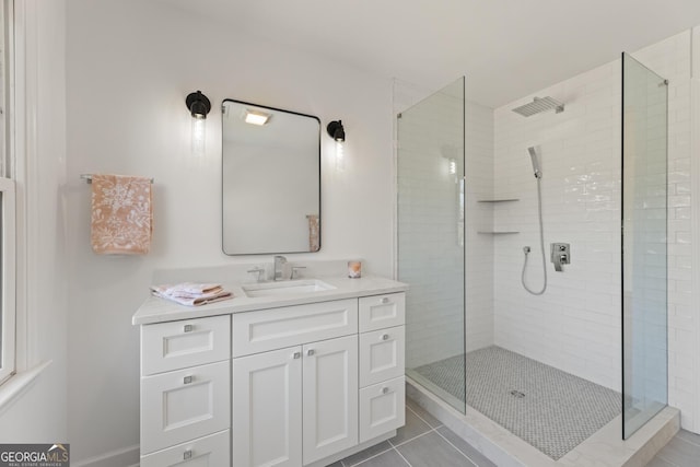 bathroom featuring tile patterned flooring, vanity, and tiled shower