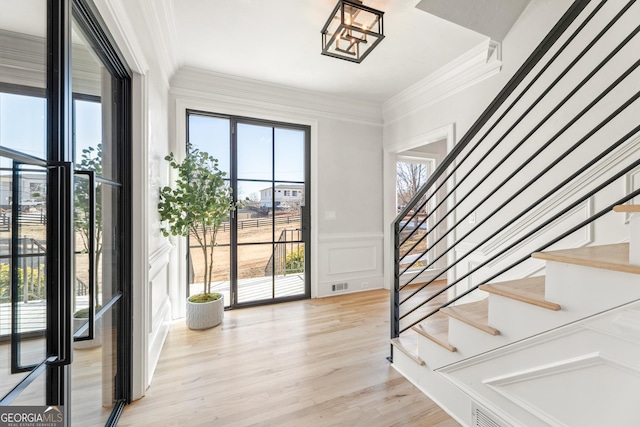 interior space featuring crown molding and light hardwood / wood-style flooring