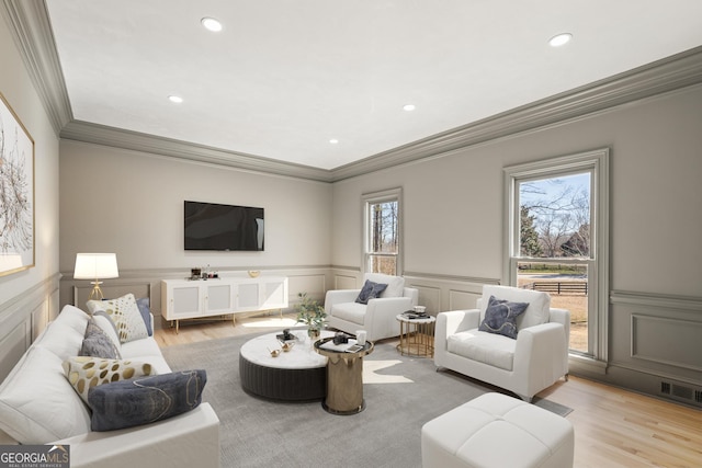 living room with ornamental molding and light wood-type flooring