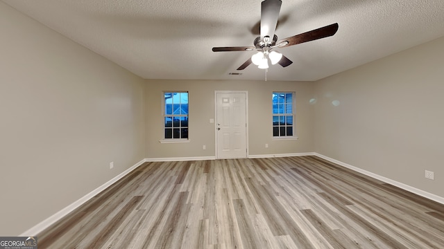 interior space with ceiling fan, a textured ceiling, and light wood-type flooring