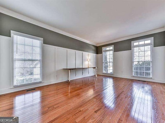 unfurnished living room featuring ornamental molding and light hardwood / wood-style flooring