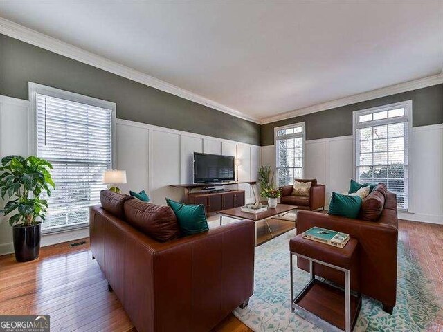 living room with crown molding and light hardwood / wood-style floors