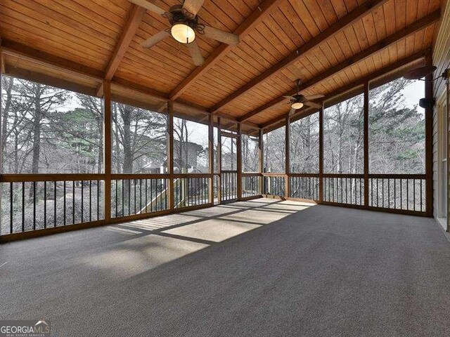 unfurnished sunroom featuring lofted ceiling with beams, wooden ceiling, and ceiling fan