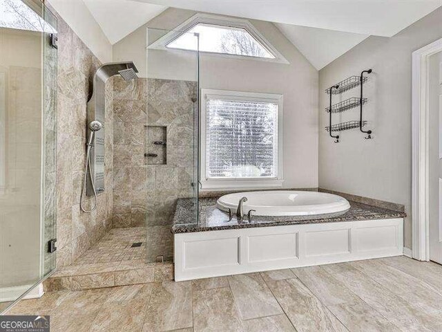 bathroom featuring lofted ceiling and shower with separate bathtub