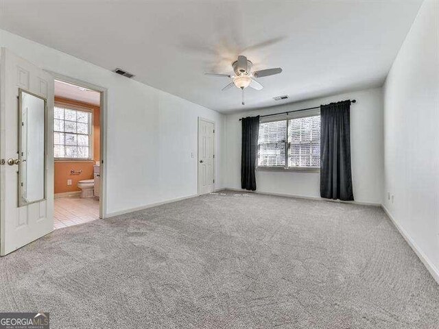 carpeted spare room with ceiling fan