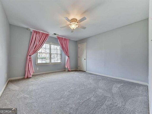 carpeted spare room with ceiling fan
