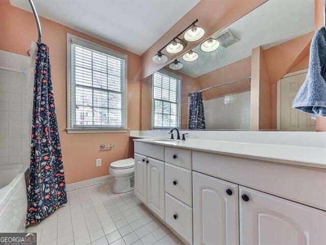 full bathroom with tile patterned flooring, vanity, shower / tub combo, and toilet