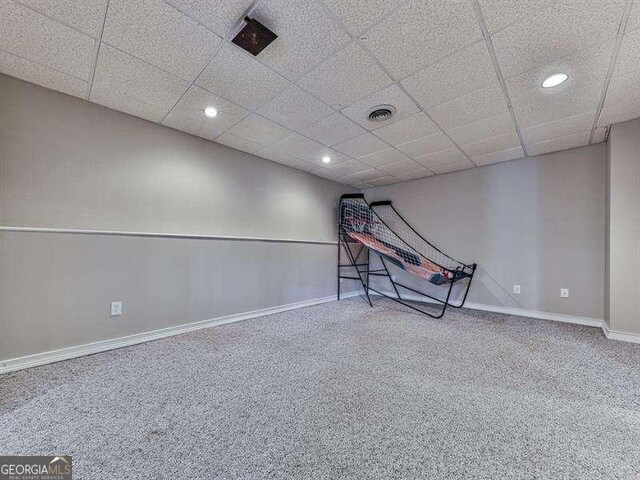 interior space with a paneled ceiling and carpet