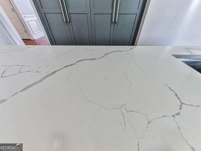 room details with gray cabinets and light stone countertops
