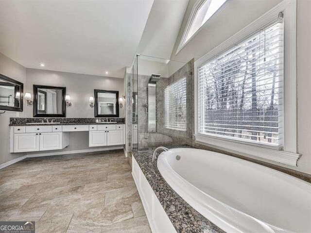 bathroom with vanity and independent shower and bath