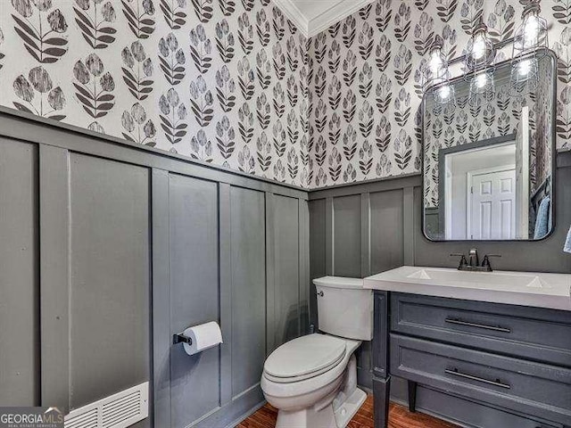 bathroom featuring crown molding, vanity, toilet, and hardwood / wood-style flooring