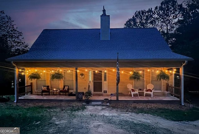 back house at dusk with a patio