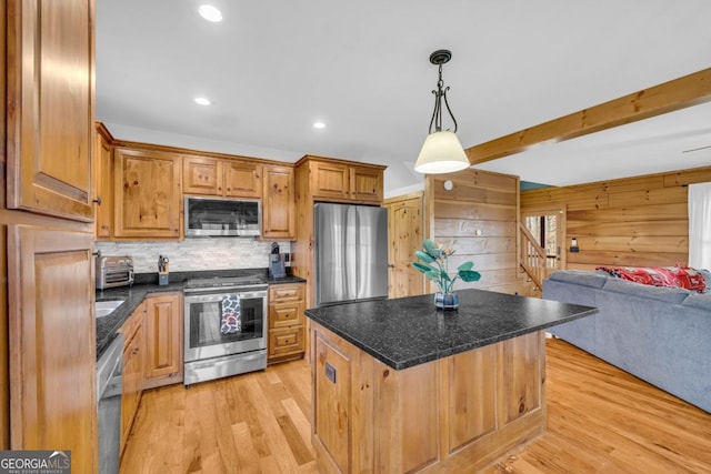 kitchen featuring decorative light fixtures, a center island, stainless steel appliances, beam ceiling, and light hardwood / wood-style floors