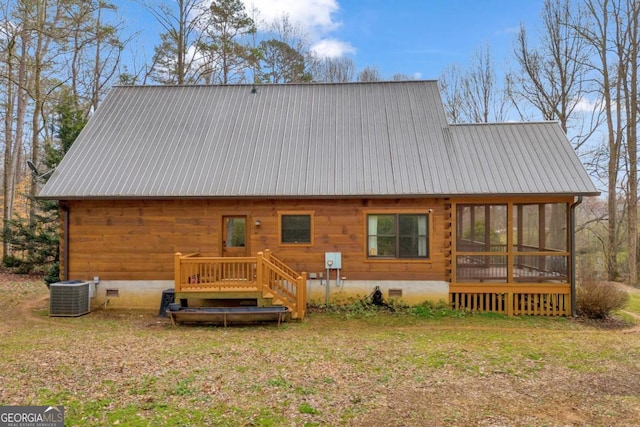 back of house featuring central AC unit, a deck, a sunroom, and a lawn