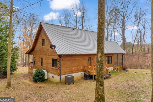 view of home's exterior with a sunroom and central AC unit