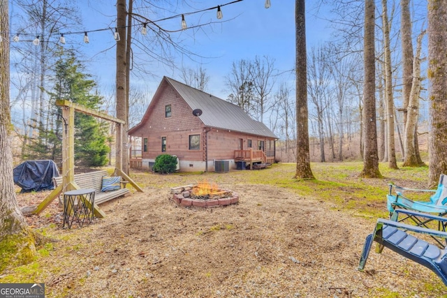 view of side of home with a wooden deck and an outdoor fire pit