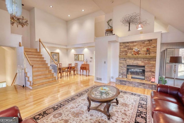 living room with hardwood / wood-style flooring, high vaulted ceiling, and a fireplace