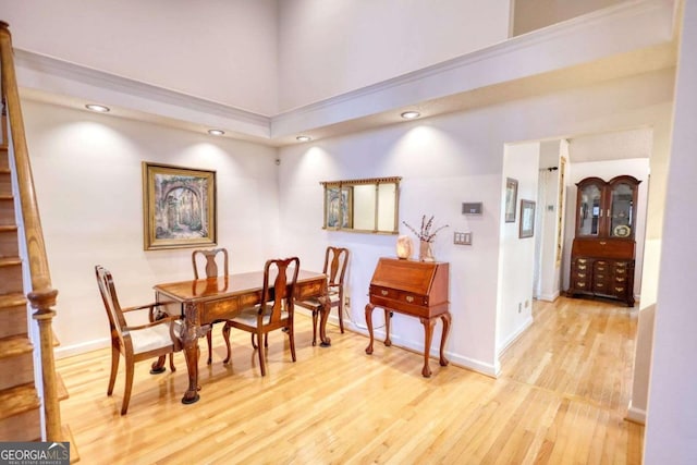 dining area featuring light hardwood / wood-style floors and a high ceiling