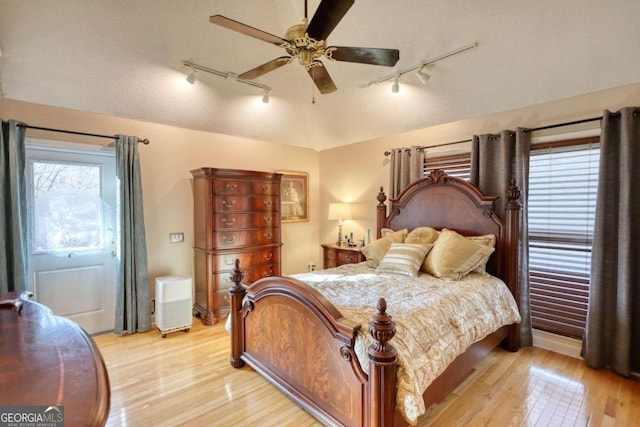 bedroom with ceiling fan, a textured ceiling, and light hardwood / wood-style flooring