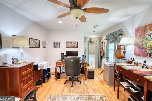 office space featuring ceiling fan, a textured ceiling, and light hardwood / wood-style flooring