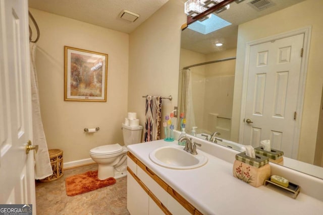 bathroom featuring a skylight, vanity, toilet, a textured ceiling, and a shower with shower curtain