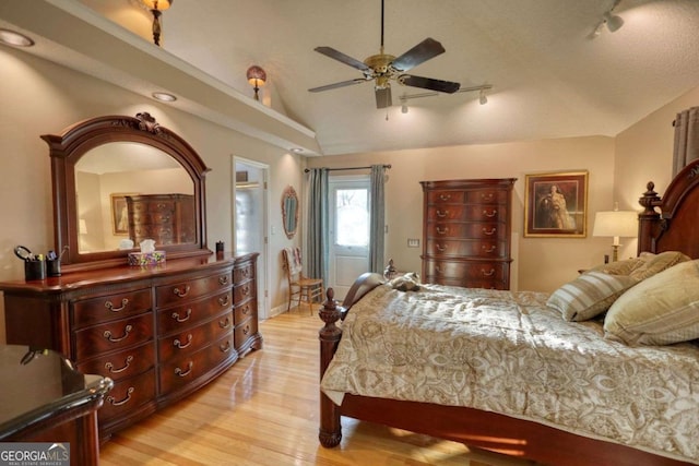 bedroom featuring vaulted ceiling, track lighting, ceiling fan, and light hardwood / wood-style flooring