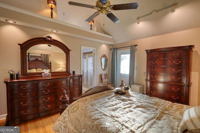 bedroom with vaulted ceiling, rail lighting, access to outside, ceiling fan, and light hardwood / wood-style floors