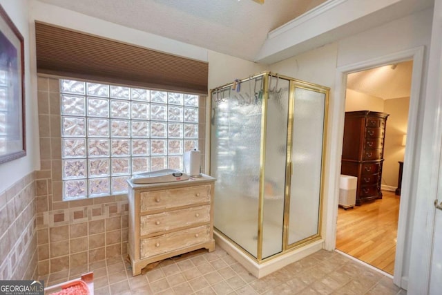 bathroom with an enclosed shower and a textured ceiling