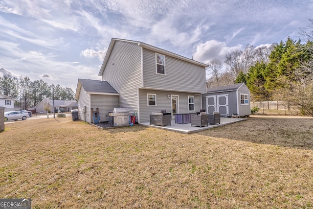 rear view of house with a patio, outdoor lounge area, a lawn, and a storage unit