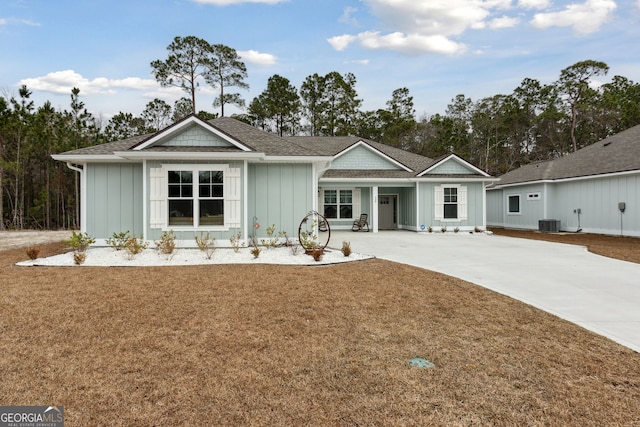 view of front of house featuring central AC and a front yard