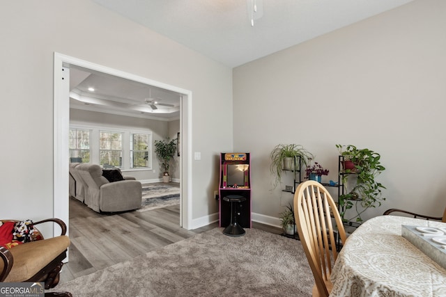 office with light hardwood / wood-style flooring, ornamental molding, a raised ceiling, and ceiling fan