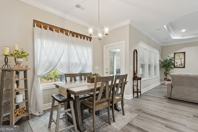 dining space featuring an inviting chandelier, hardwood / wood-style floors, and crown molding