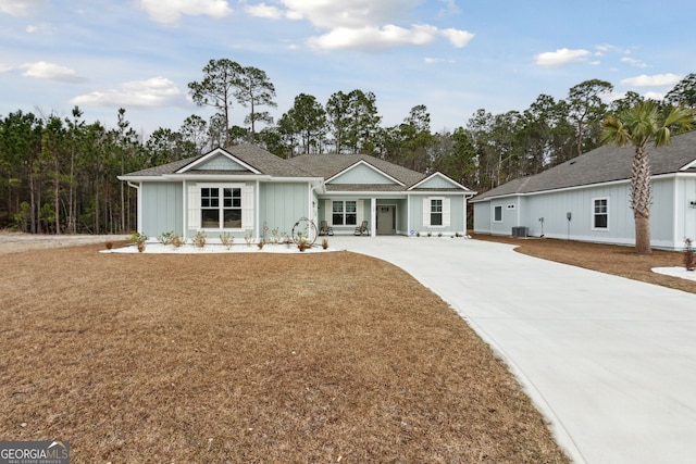 ranch-style house with a front yard and central AC unit