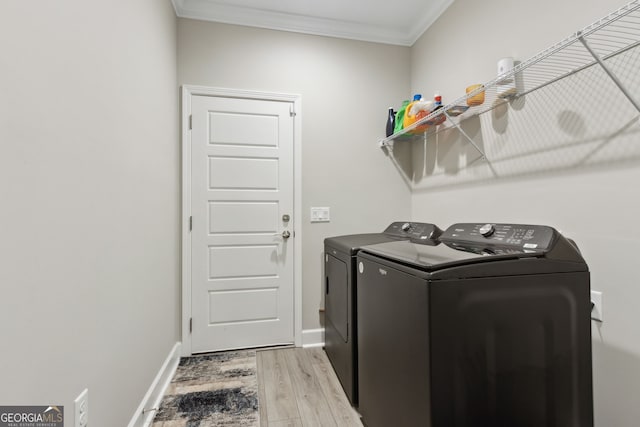 washroom with hardwood / wood-style flooring, ornamental molding, and washer and dryer