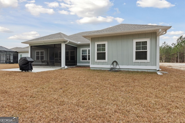 back of house featuring a yard, a patio, and a sunroom