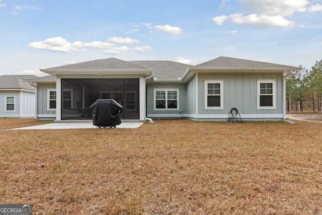 rear view of house with a yard, a patio area, and a sunroom