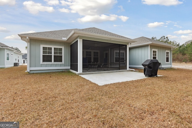 back of property featuring a yard, a patio area, and a sunroom